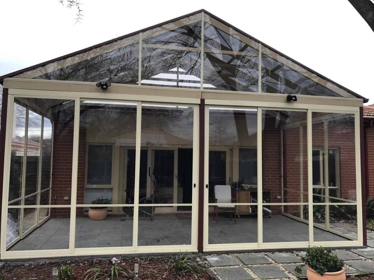 Gable infill glazing enclosing the peaked roofline of a home patio